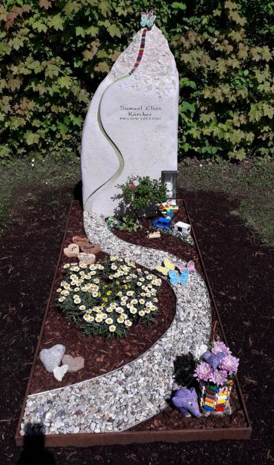 Kindergrabstein mit Weg aus Legosteinen und Schmetterlingen
